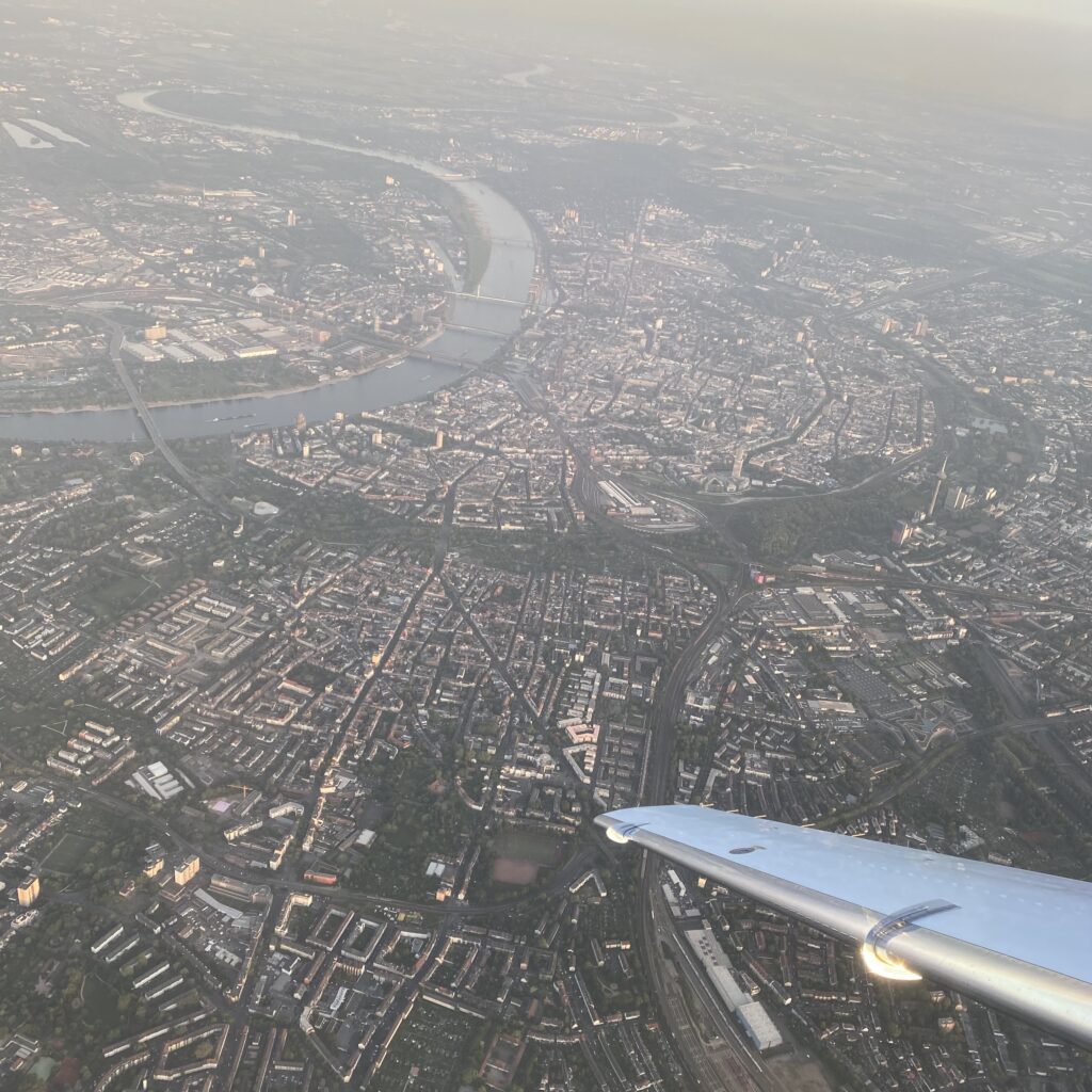 Blick aus dem Flugzeug auf eine Stadt mit Fluss